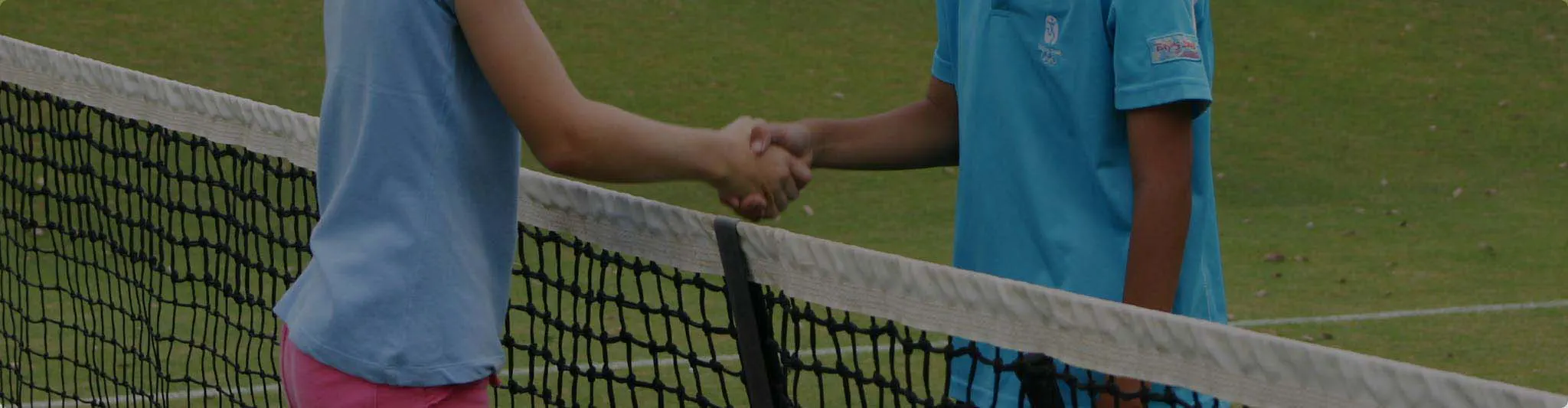 Junior tennis players shaking hands at the net