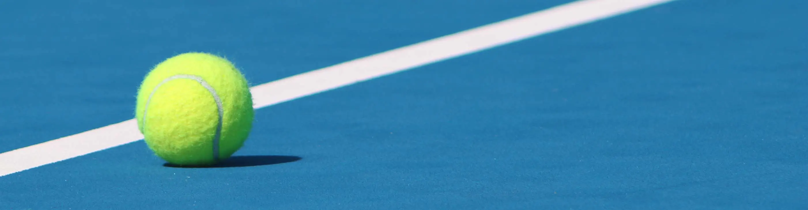 Tennis ball on blue hard court